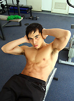 Young jock shows his sixpack in a gym by Bentley Race
