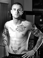 The heavily tattooed tough guy demurely stands on the scales covering his cock and balls by Ruggerbugger
