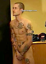 The heavily tattooed tough guy demurely stands on the scales covering his cock and balls by Ruggerbugger
